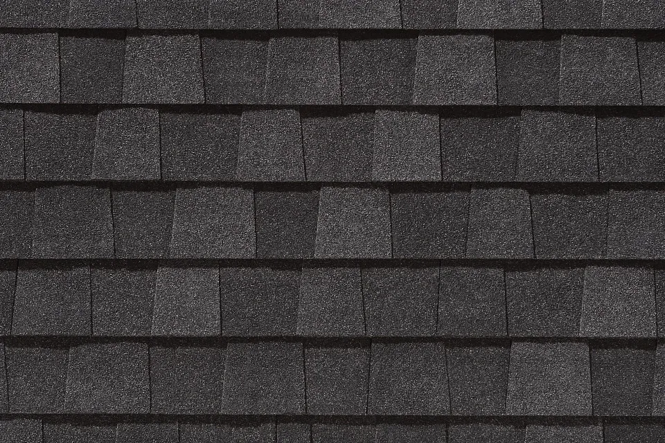 A close up of a row of black shingles on a roof.