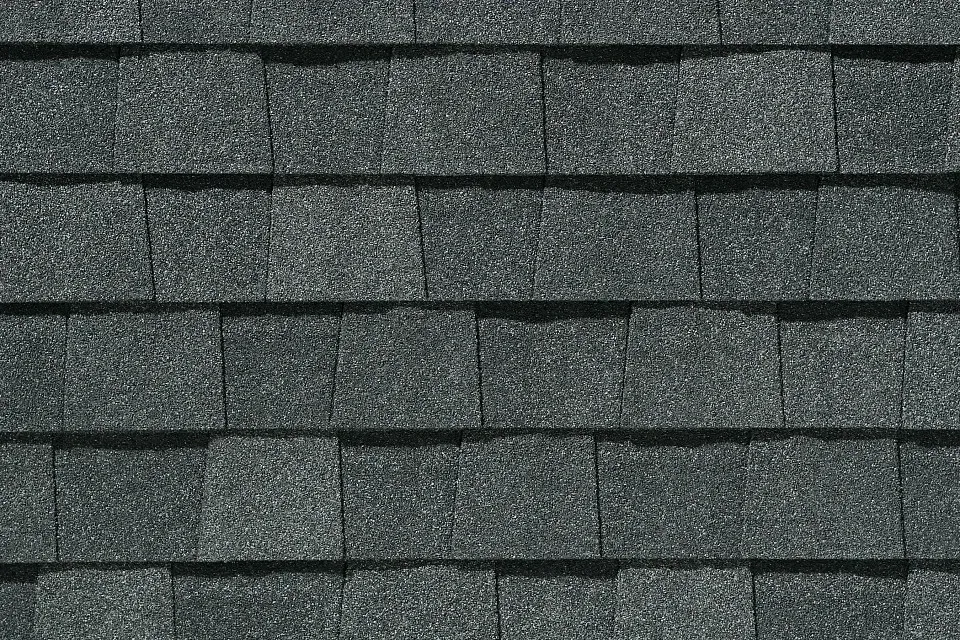 A close up of a row of gray shingles on a roof.