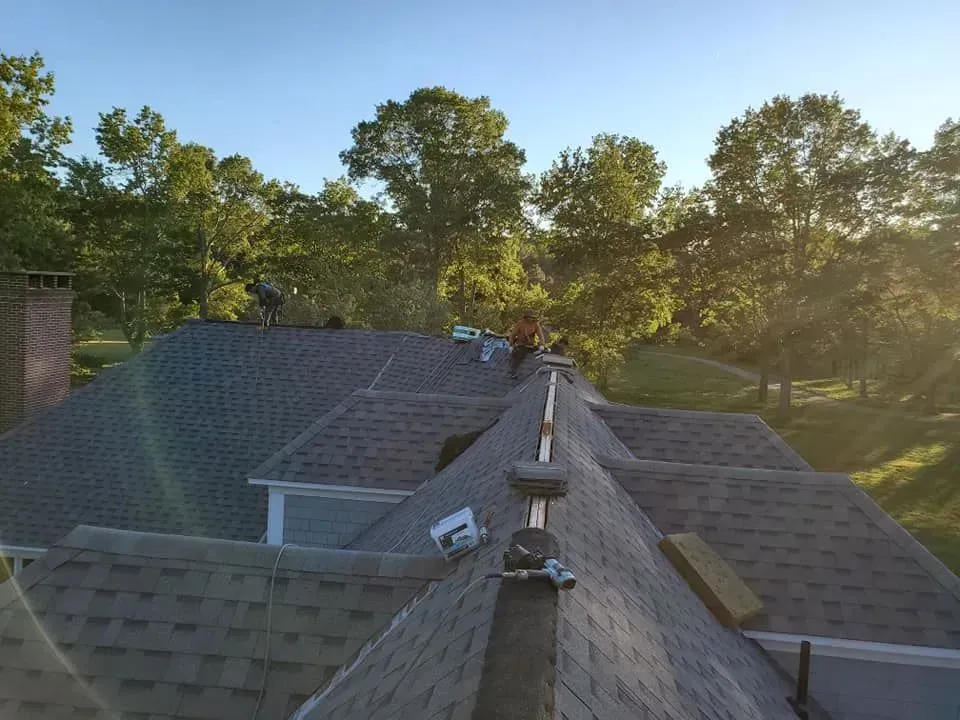A man is working on the roof of a house