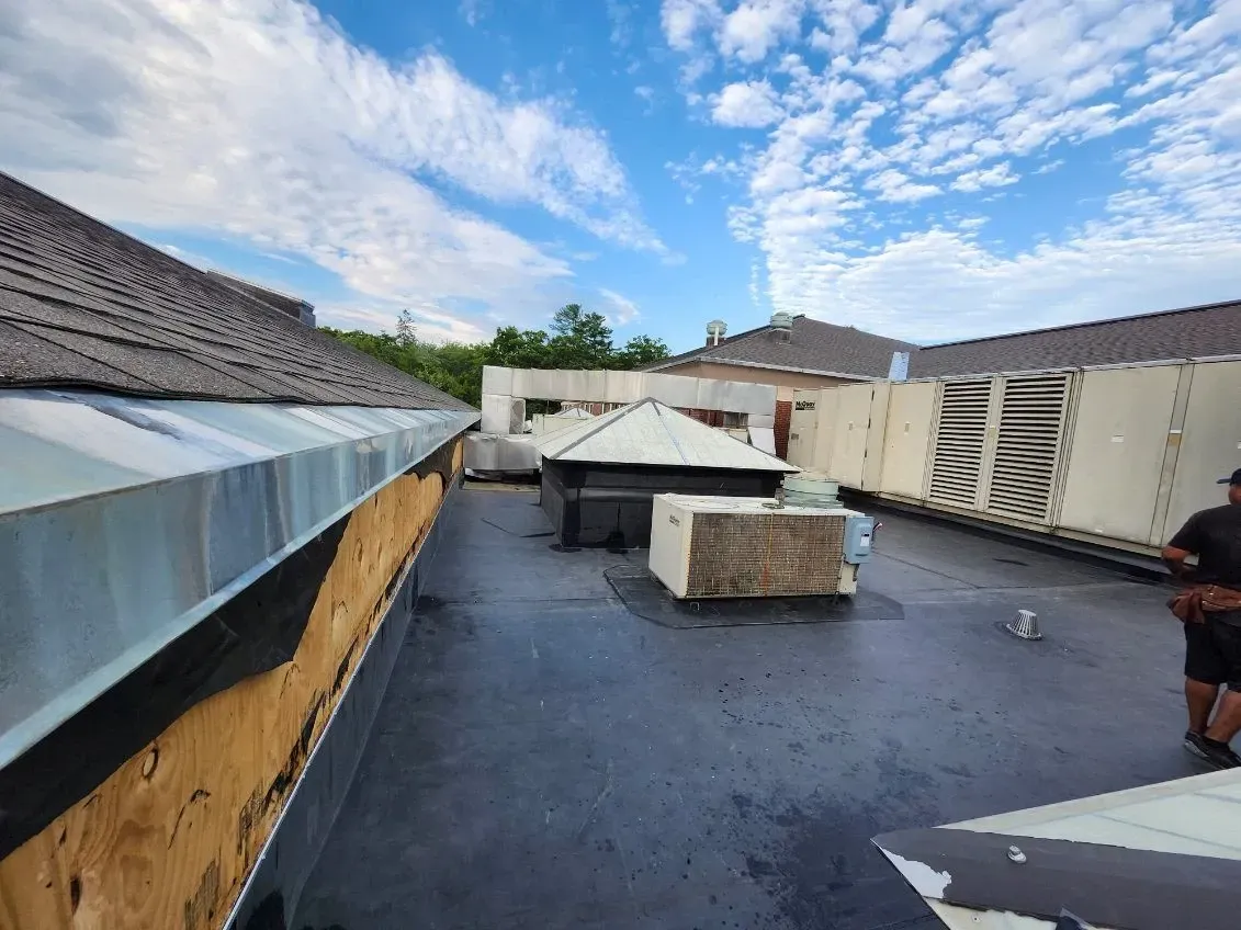 A man is standing on the roof of a building.
