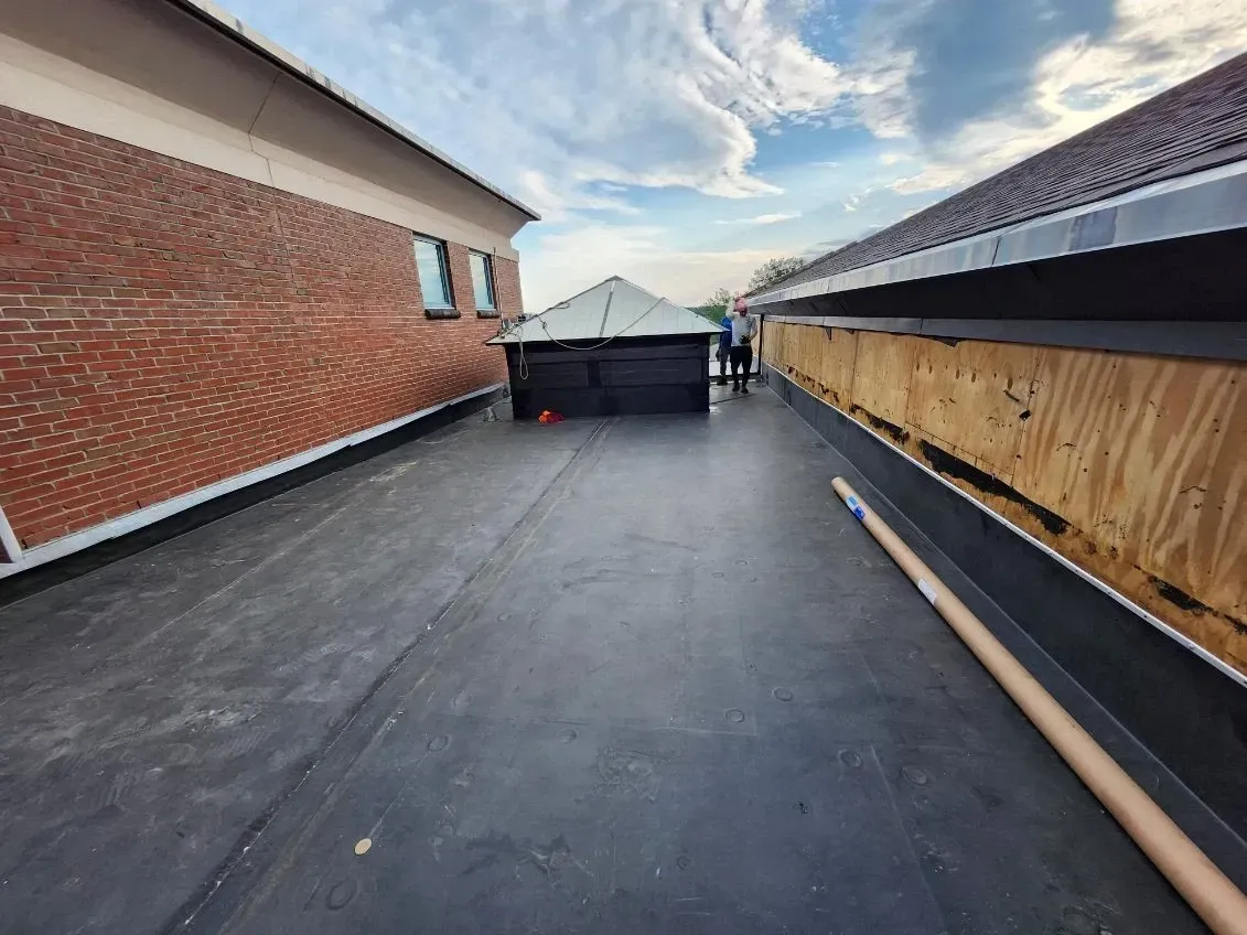 A black roof is being installed on the side of a building.
