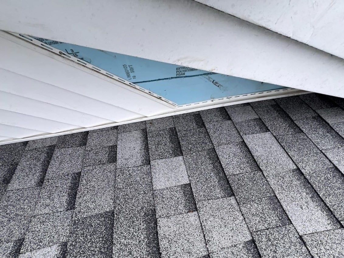 A close up of a roof with shingles and a white roof.