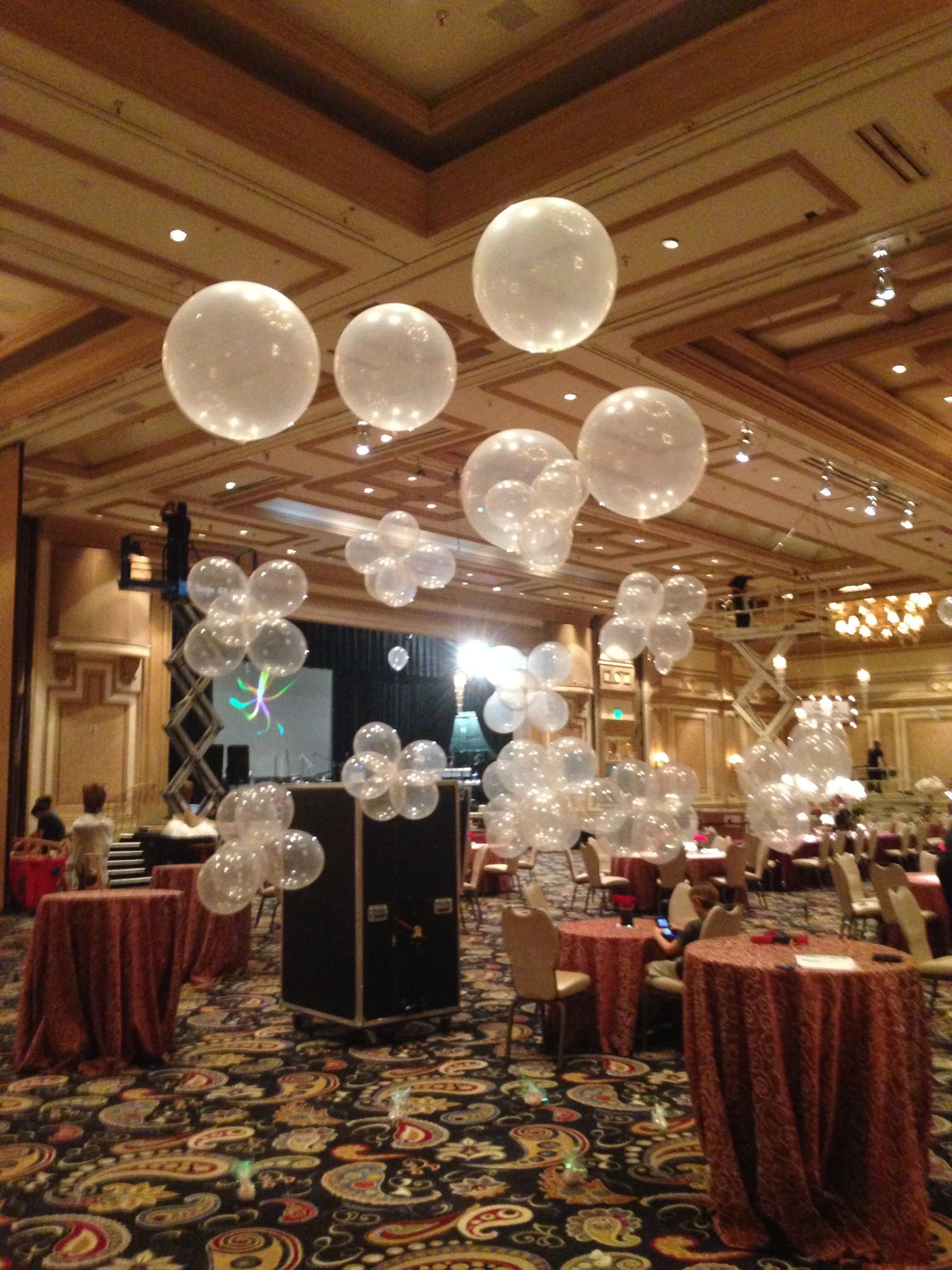 A large room with tables and balloons hanging from the ceiling