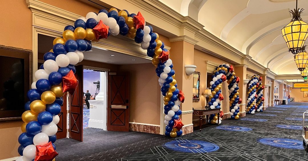 A hallway filled with balloons and a balloon arch.