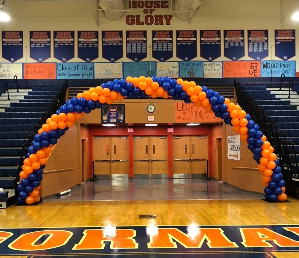 A blue and orange balloon arch in front of a sign that says house of glory