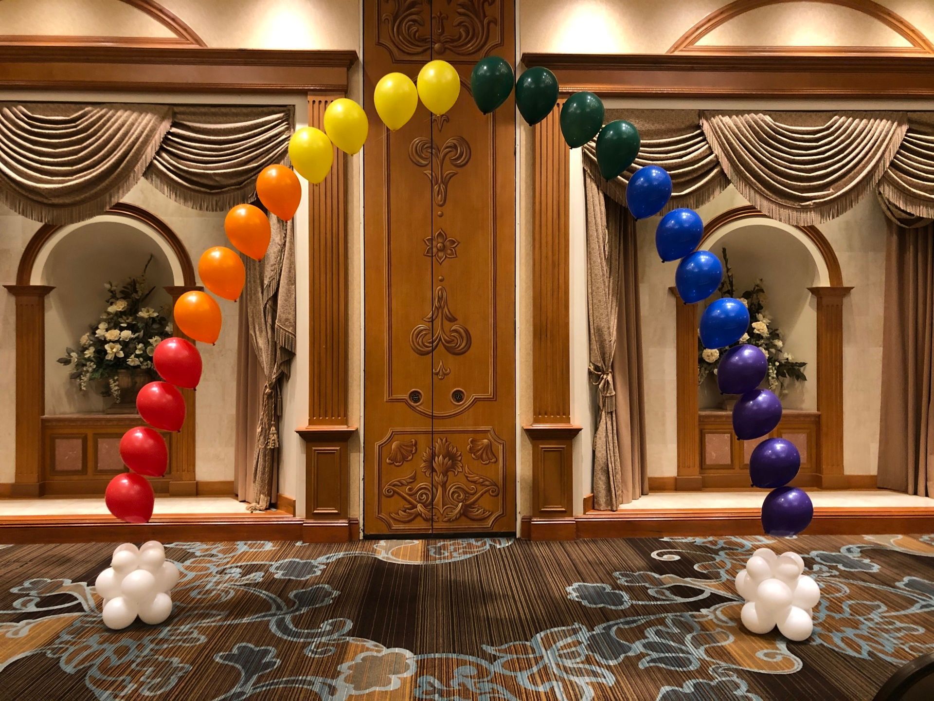 A room decorated with balloons in the shape of a rainbow.
