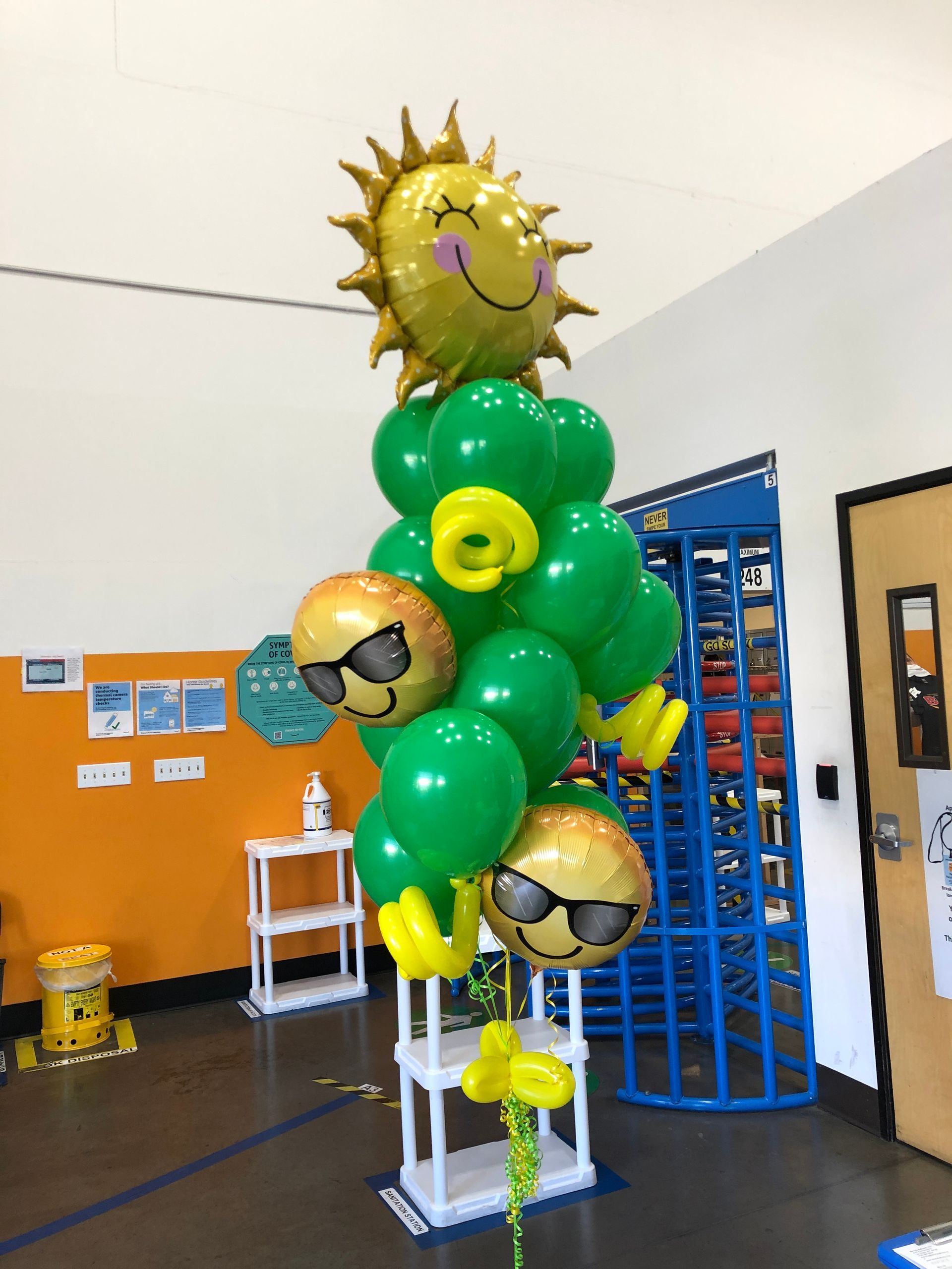 A bunch of green balloons with smiley faces on them