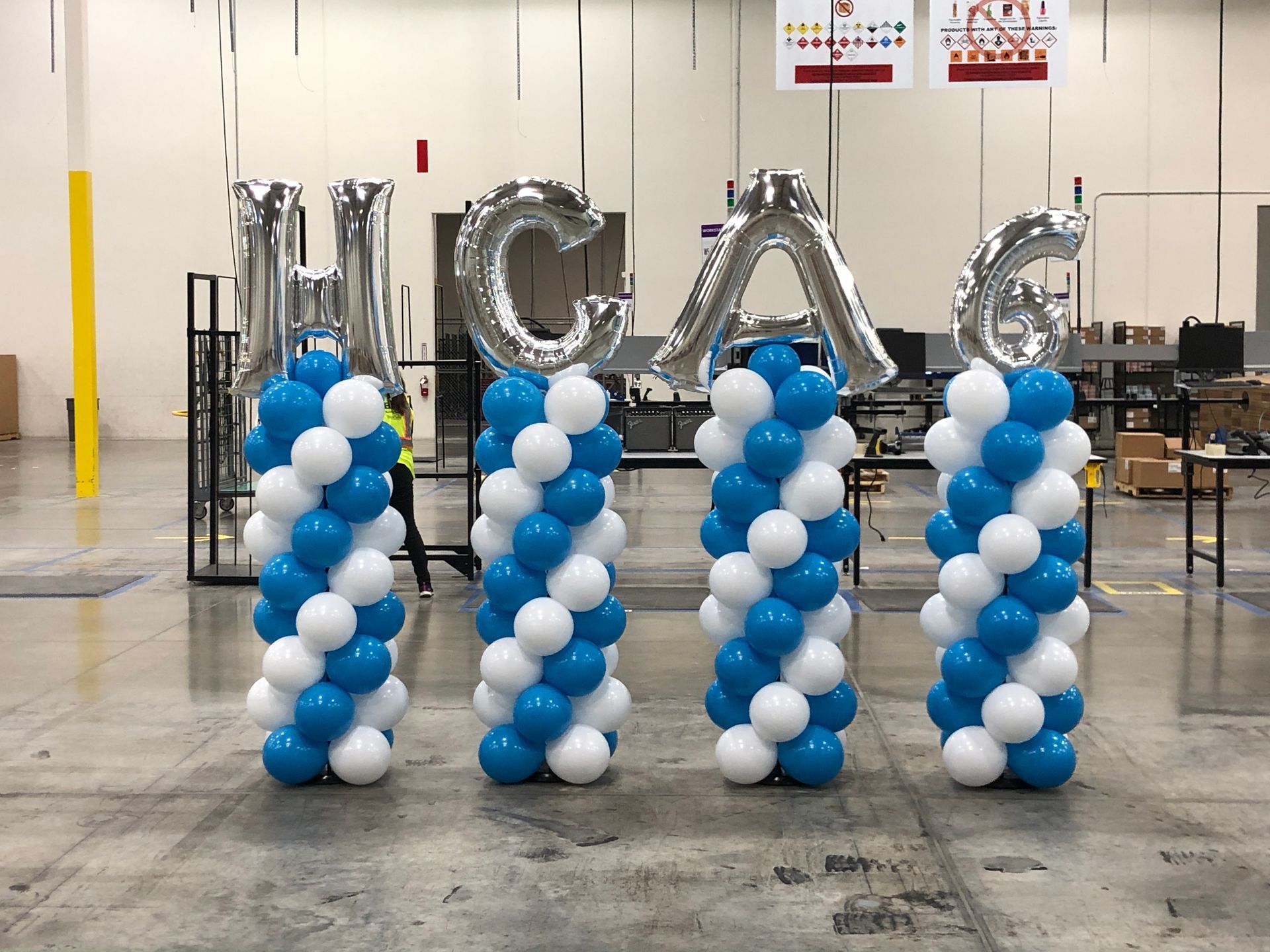 Three columns of blue and white balloons with the word hcag on them