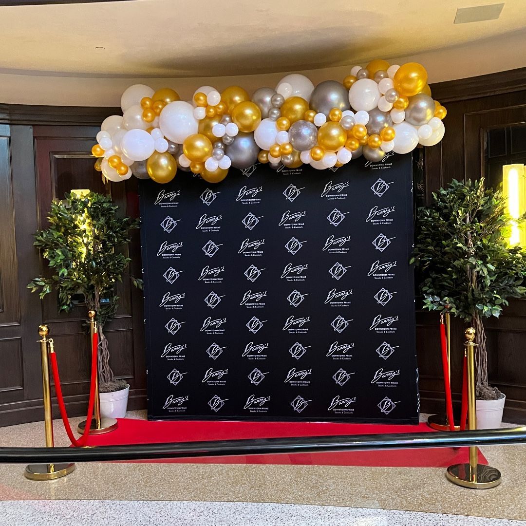 A wall with balloons on it and a red carpet