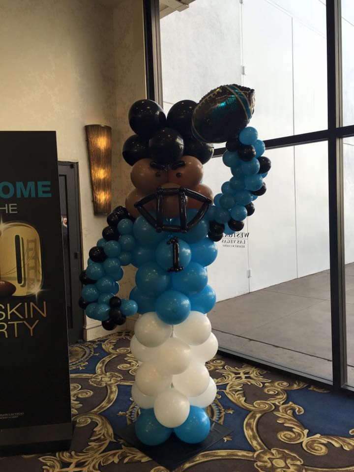 A balloon sculpture of a football player holding a football.