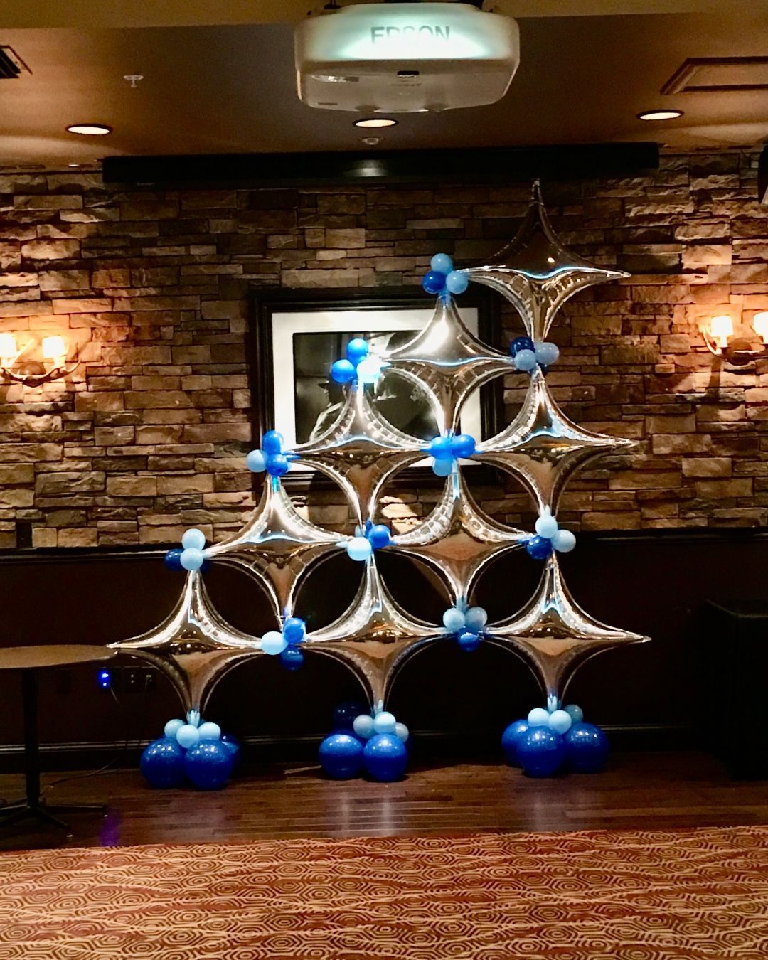 A room filled with balloons and a projector.