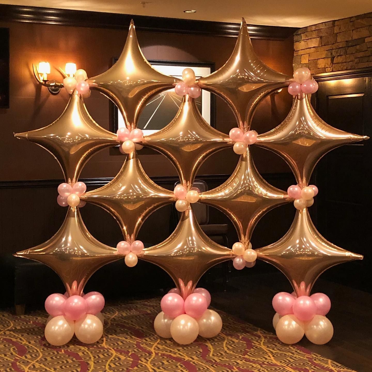 A display of gold and pink balloons in a room