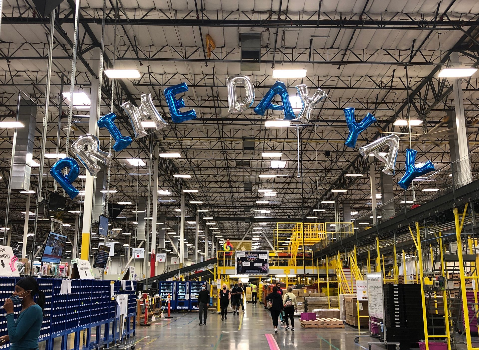 A large warehouse with blue and silver balloons hanging from the ceiling.