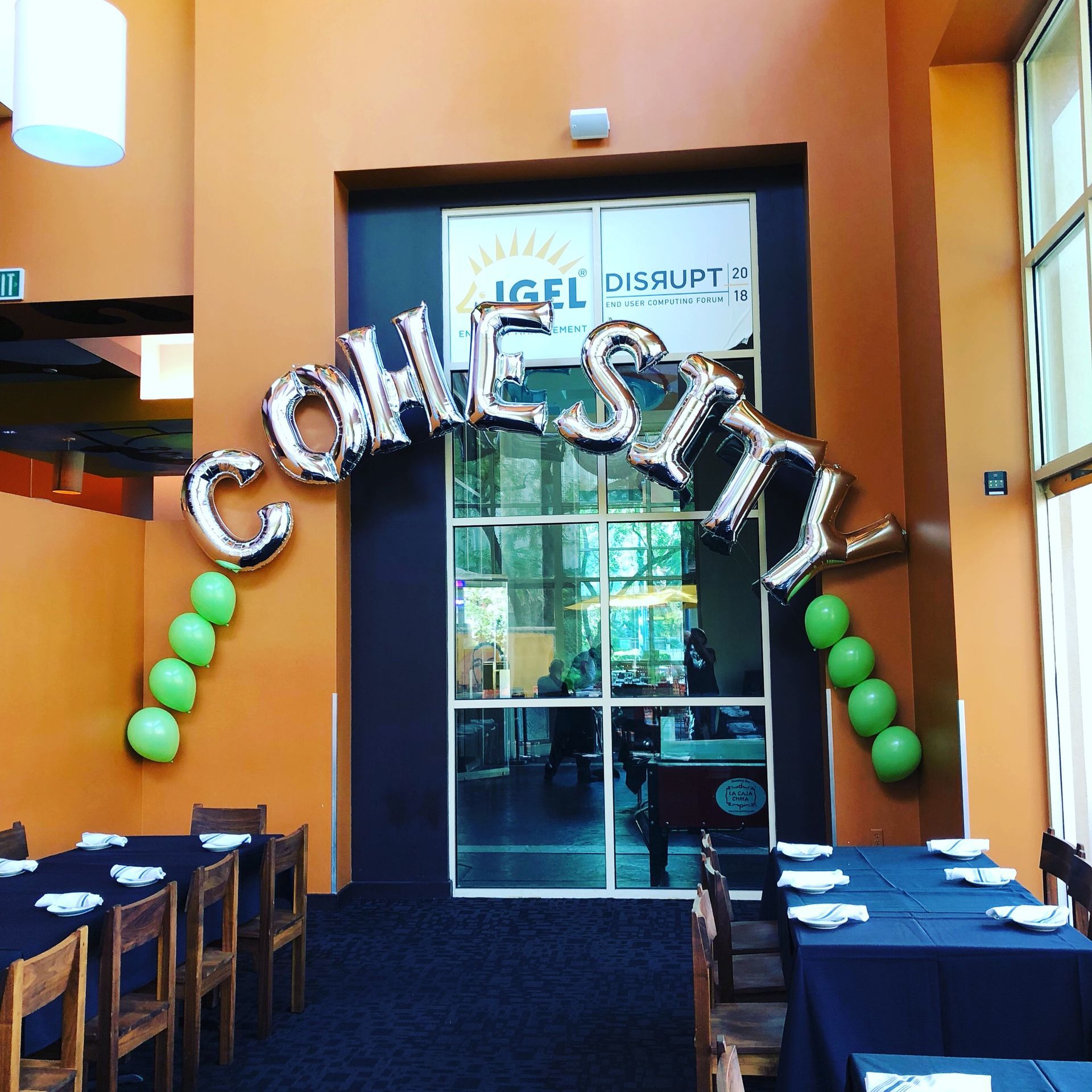 A room with tables and chairs and a sign that says come sit