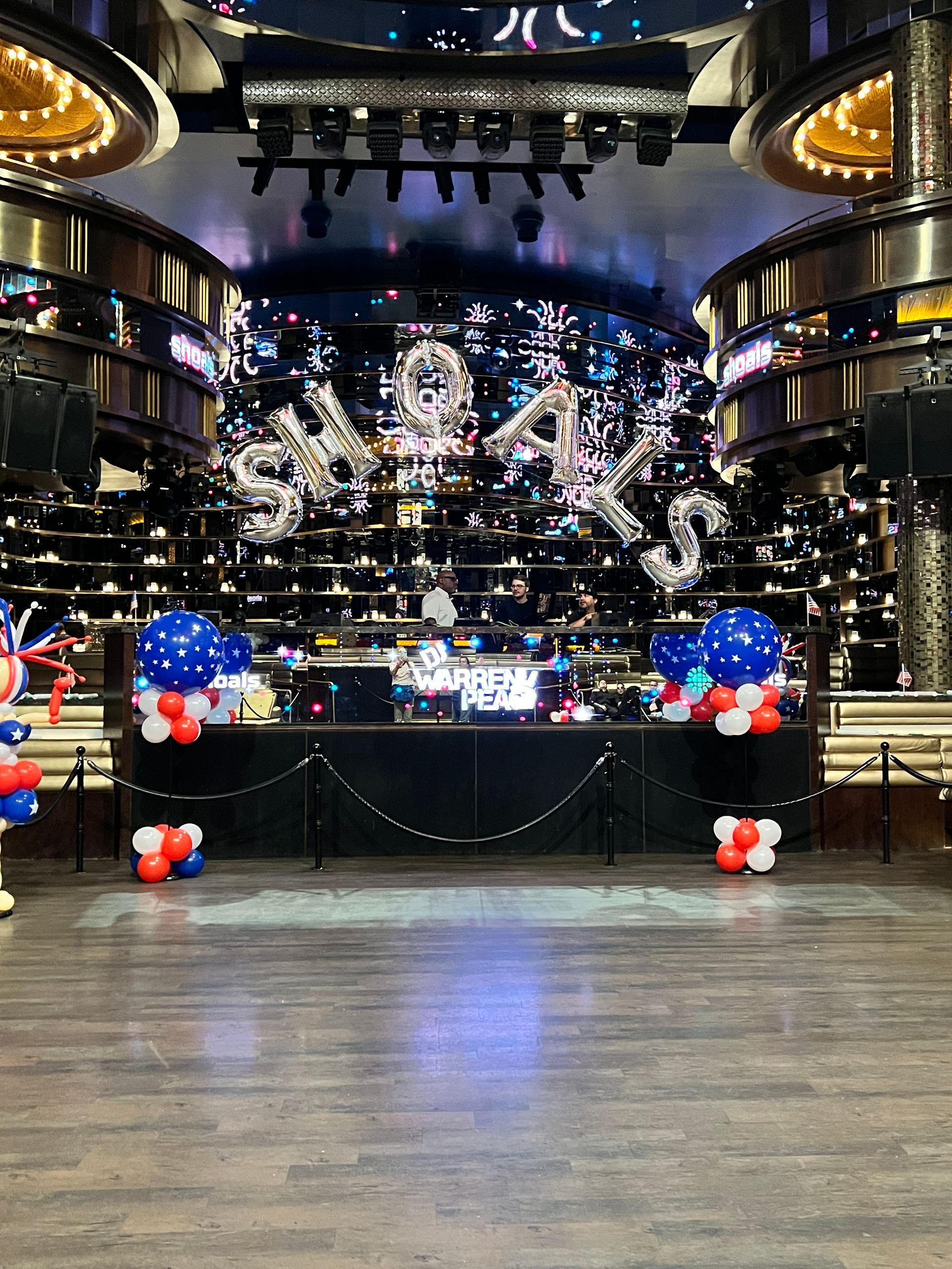 A large room with balloons on the floor and a stage in the background