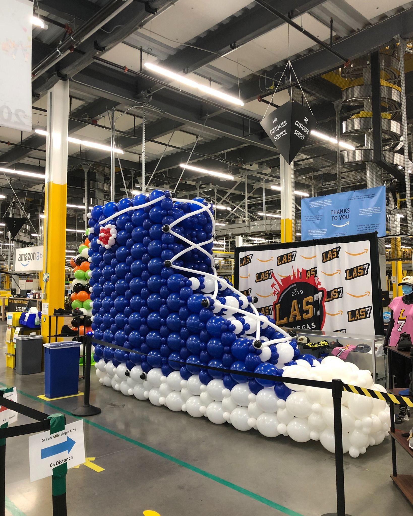 A large shoe made out of balloons in a warehouse