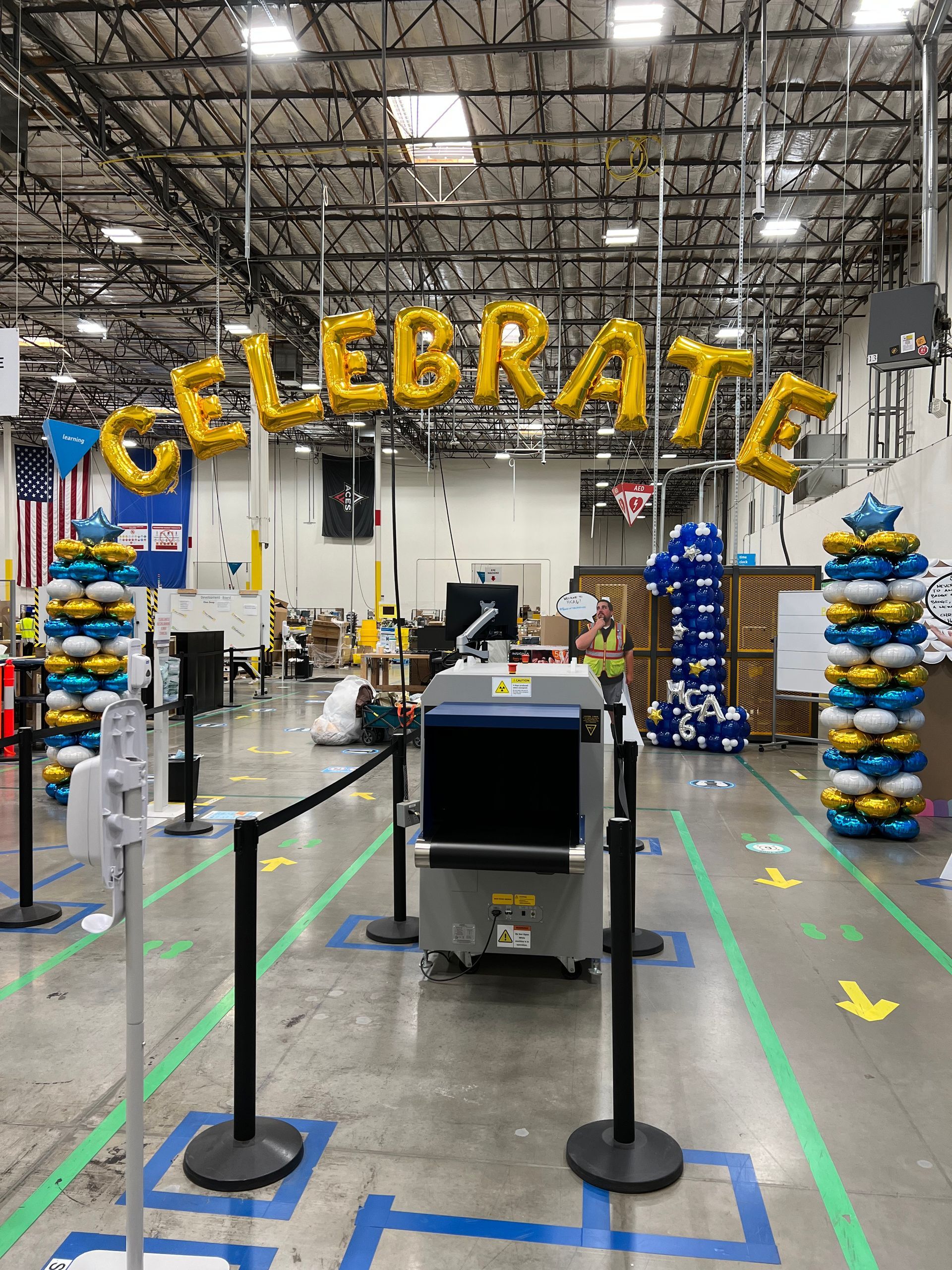 A warehouse is decorated with balloons and a sign that says celebrate