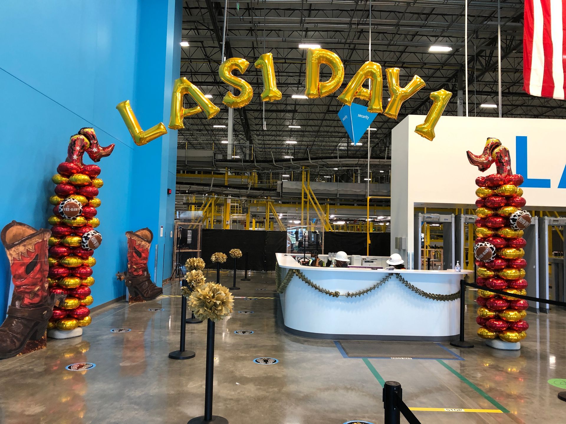 A large room with balloons and a sign that says last day.