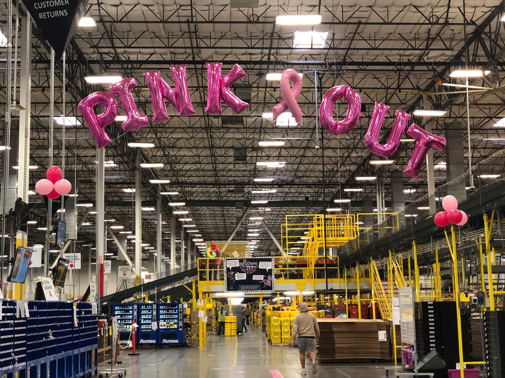 A warehouse with pink balloons that say pink out
