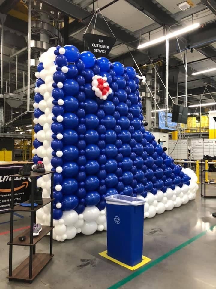 A wall of blue and white balloons in the shape of a shoe