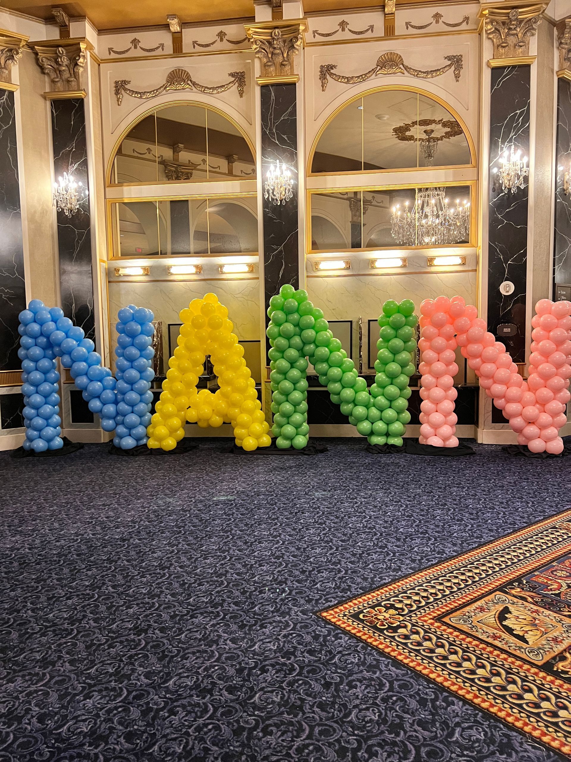 The word nann is made out of balloons in a room.