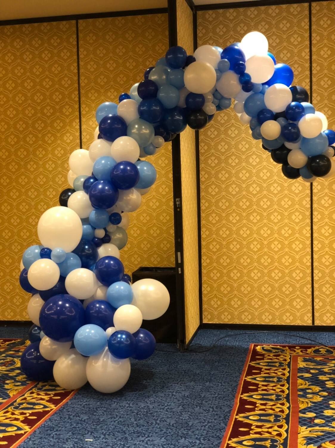 A blue and white balloon arch in a room