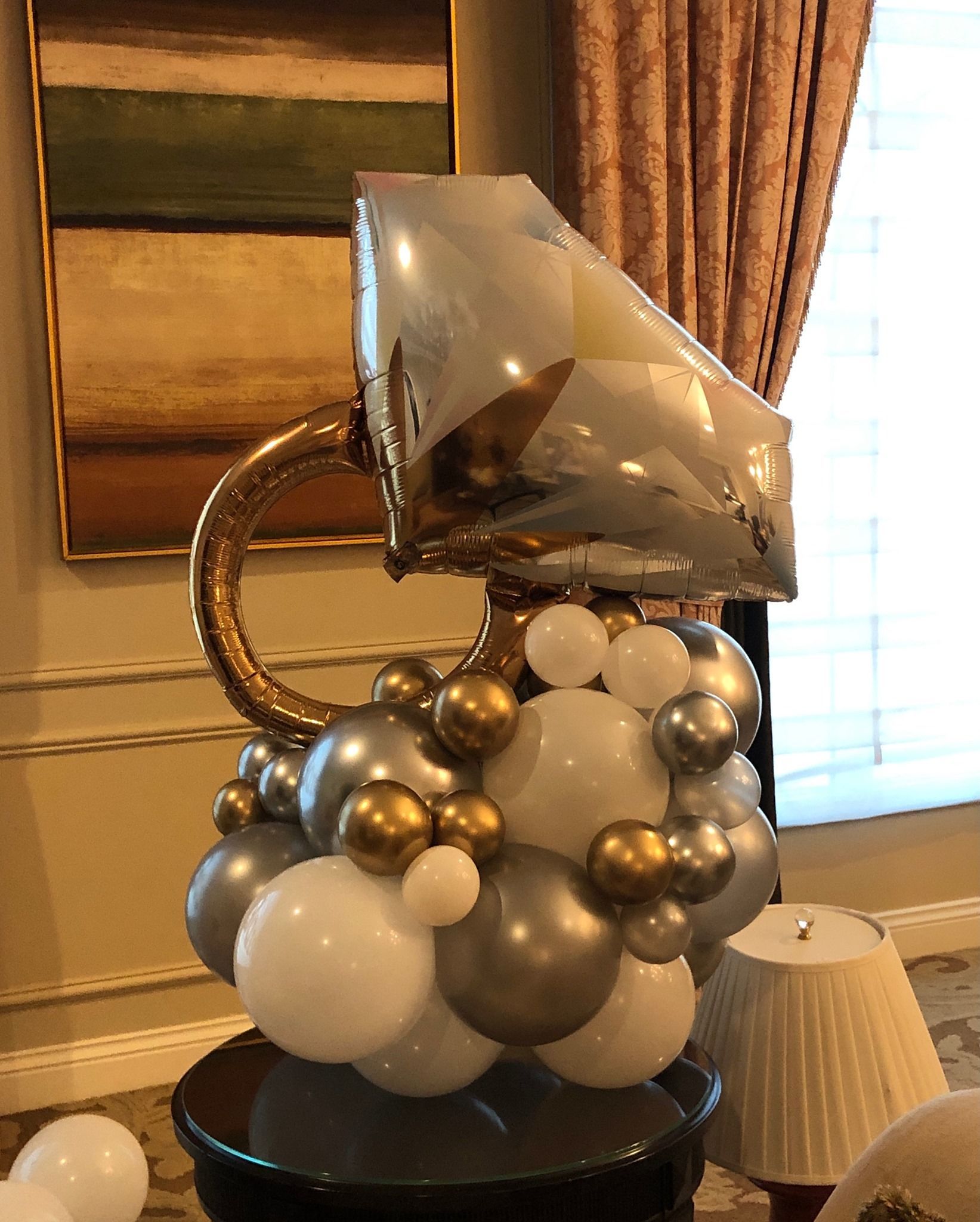 A balloon shaped like a diamond ring is sitting on top of a table.