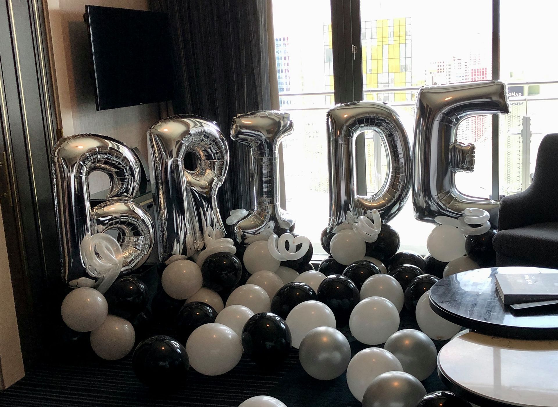 A room filled with balloons and letters that spell out the word bride.