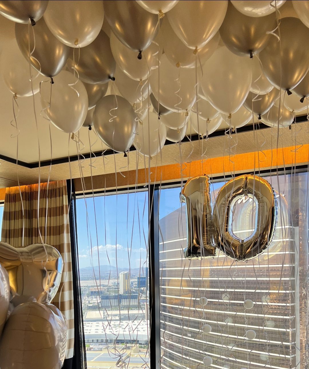 A bunch of balloons are hanging from the ceiling in a room