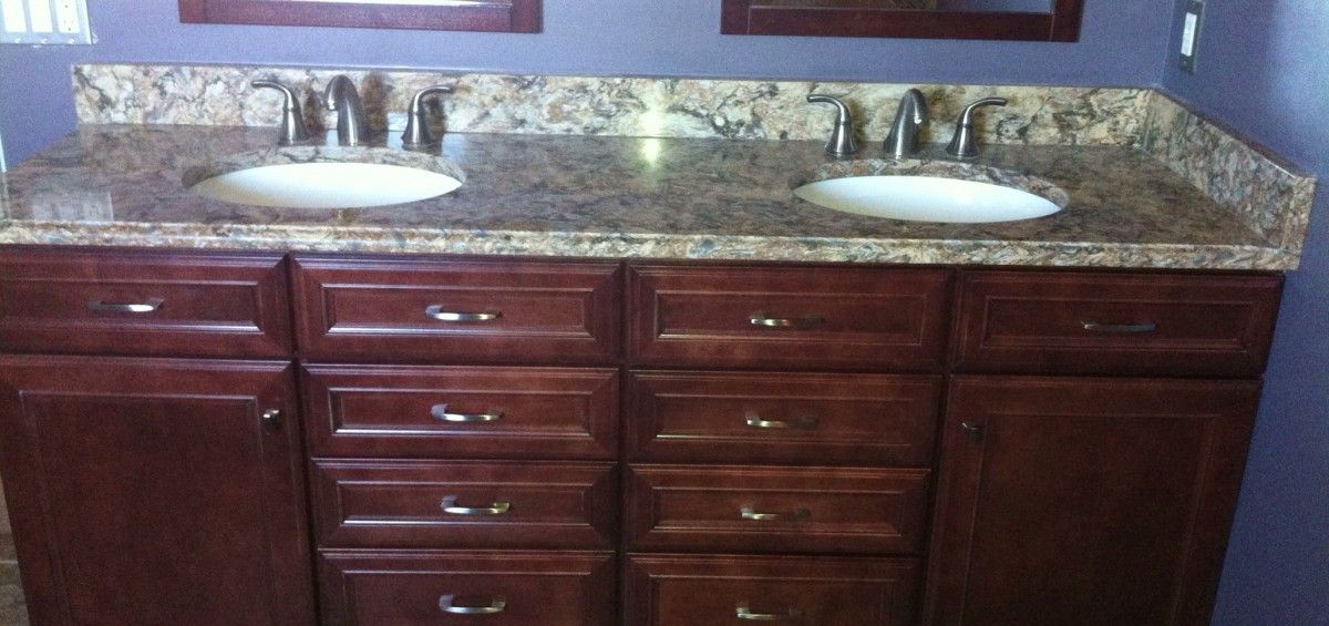 Bathroom vanity with two sinks, granite countertop, and dark brown cabinets.