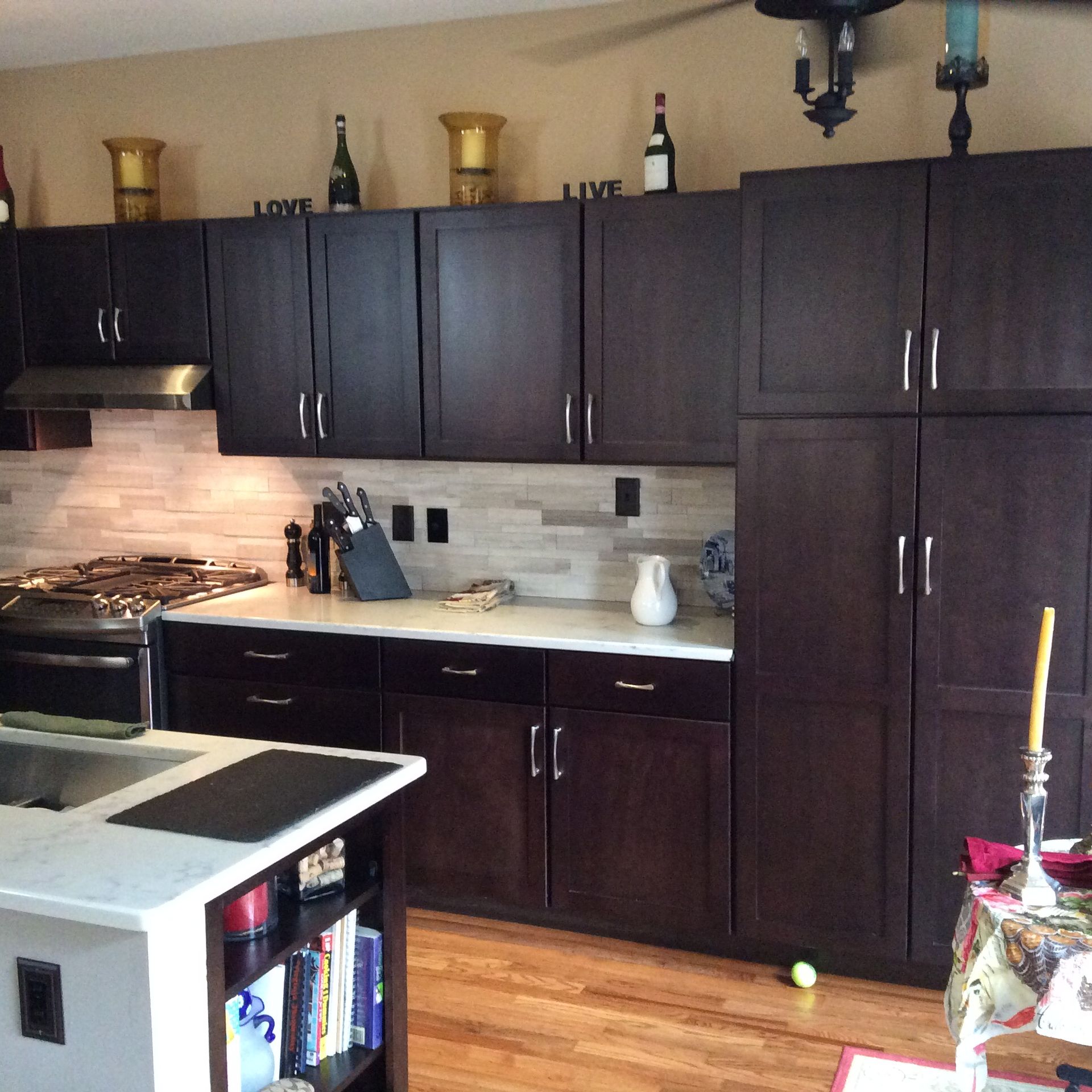 Dark wood kitchen with white countertops and backsplash; food prep area.