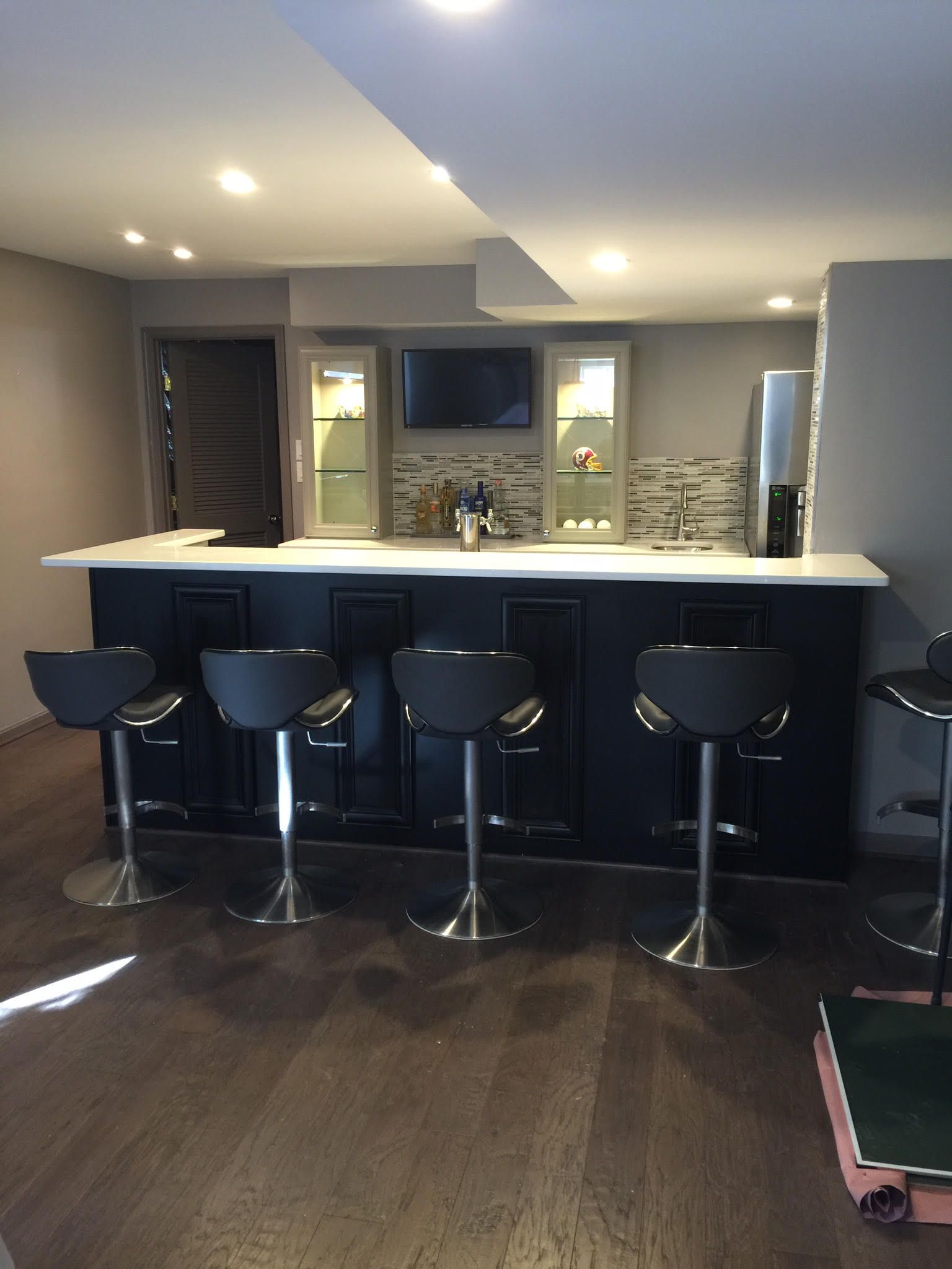 A kitchen with a bar and stools in it