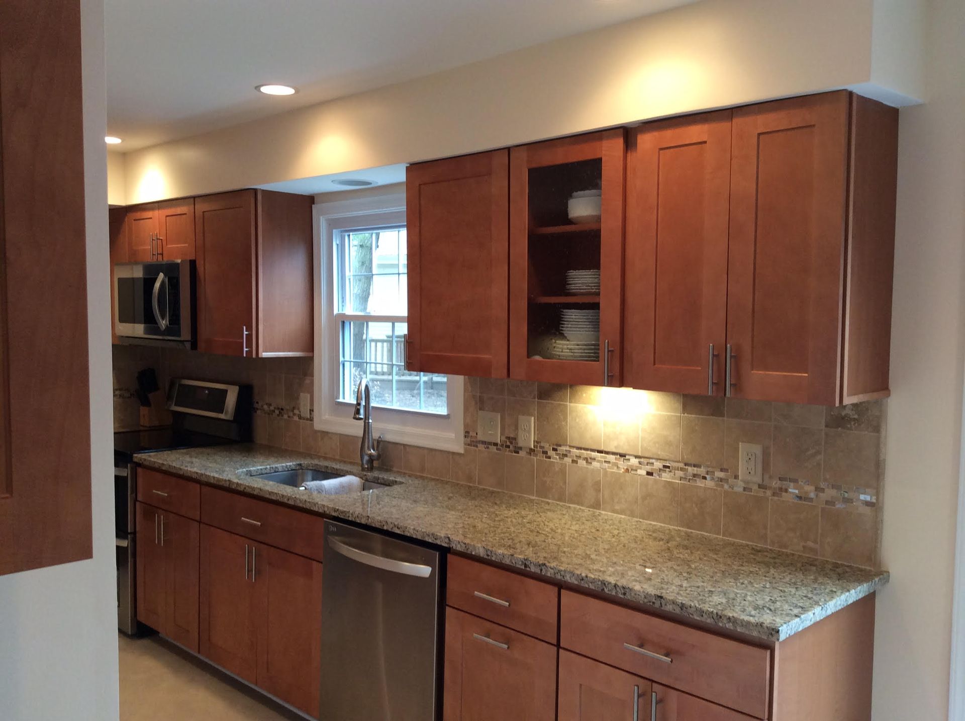 Kitchen with wooden cabinets, granite countertops, and stainless steel appliances.