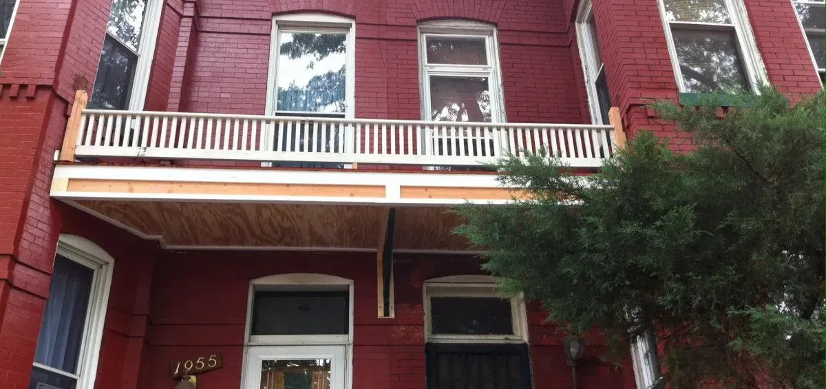 Red brick building with a porch.