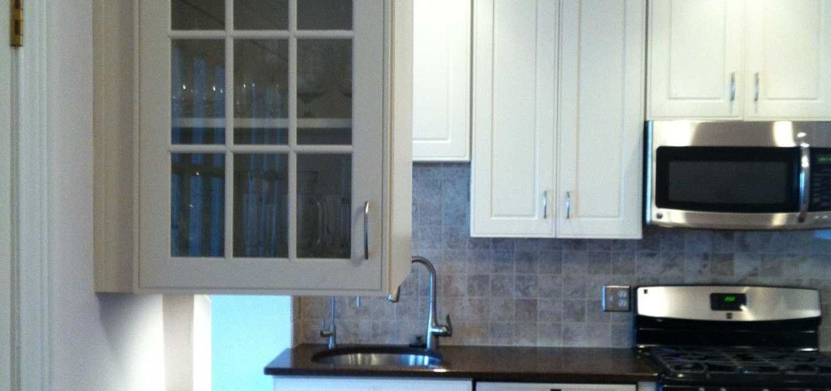 Kitchen with white cabinets, stainless steel appliances, and a dark countertop.