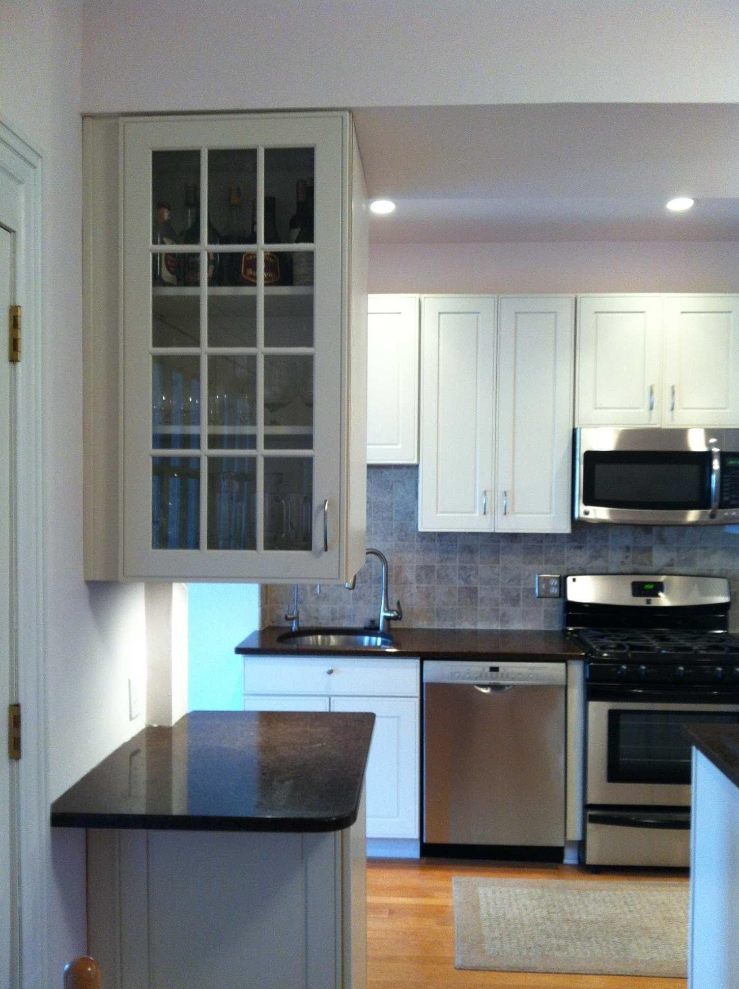 Kitchen with white cabinets, stainless steel appliances, and dark countertops.