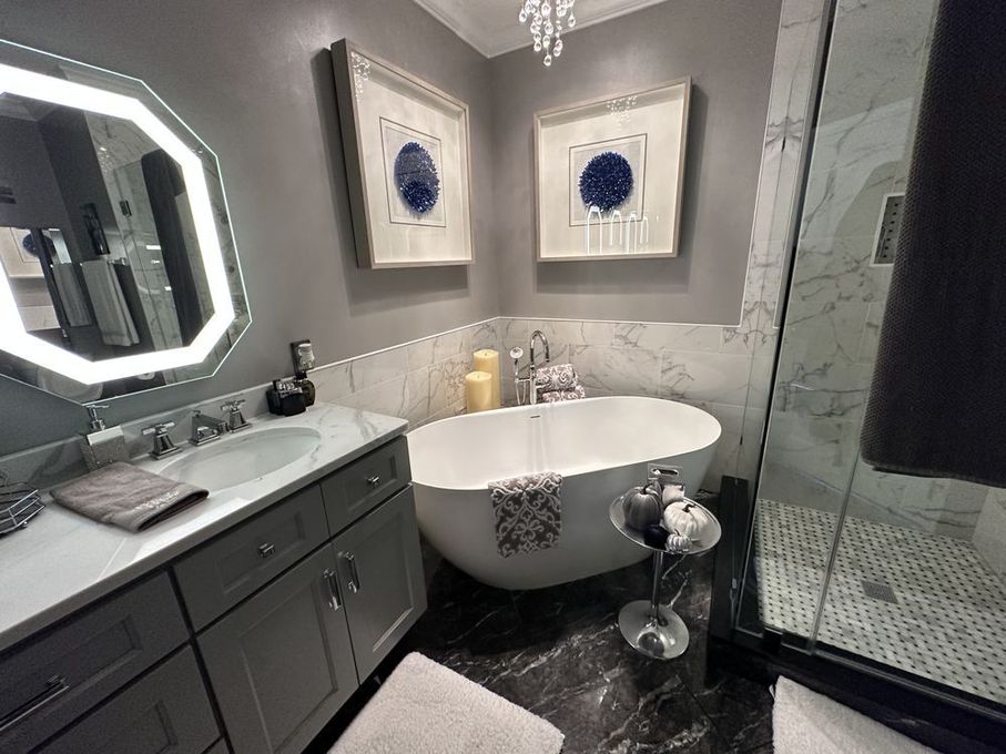A bathroom with a bathtub , sink , mirror and shower.