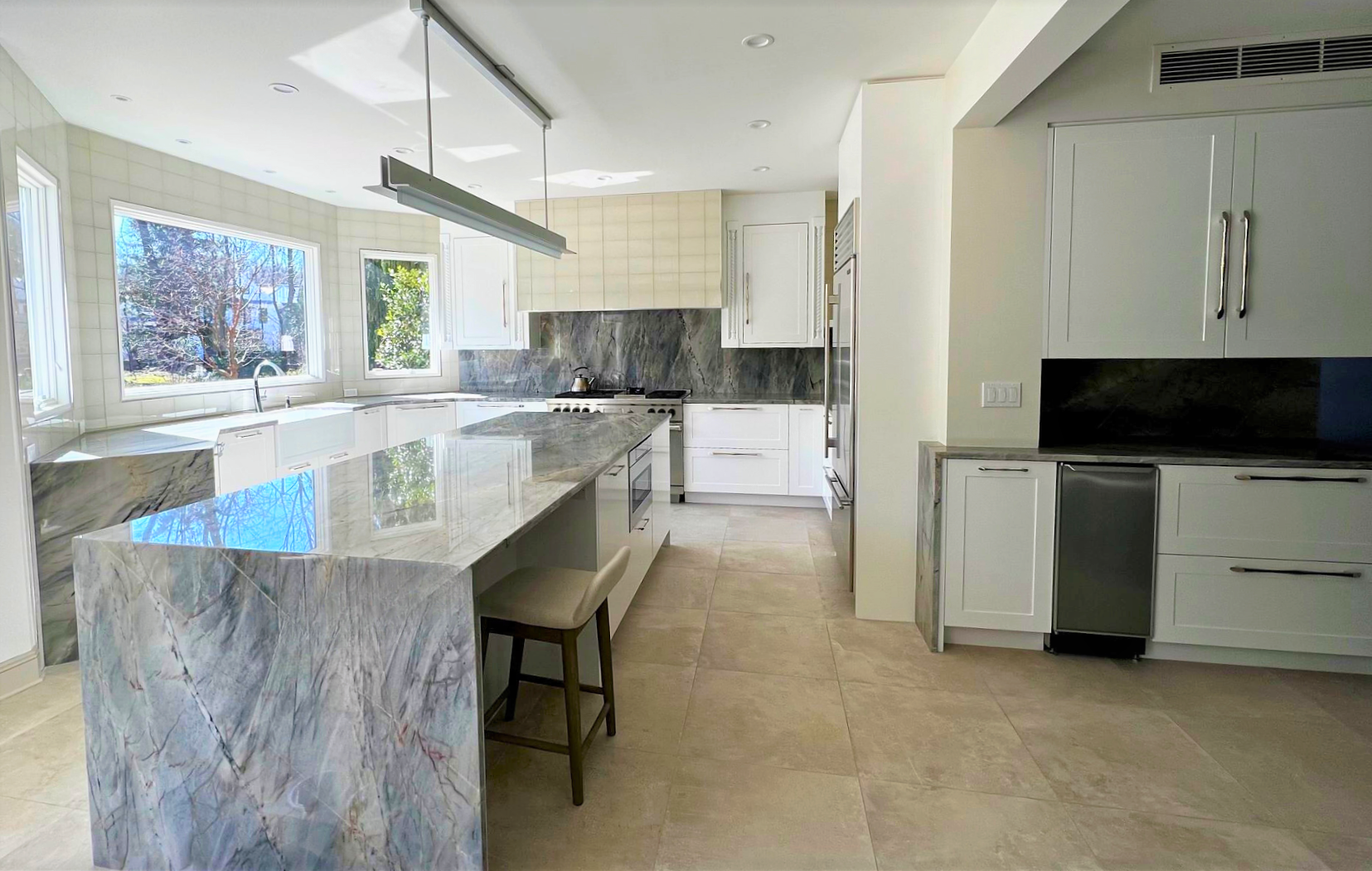 kitchen with white cabinets and marble countertops and island