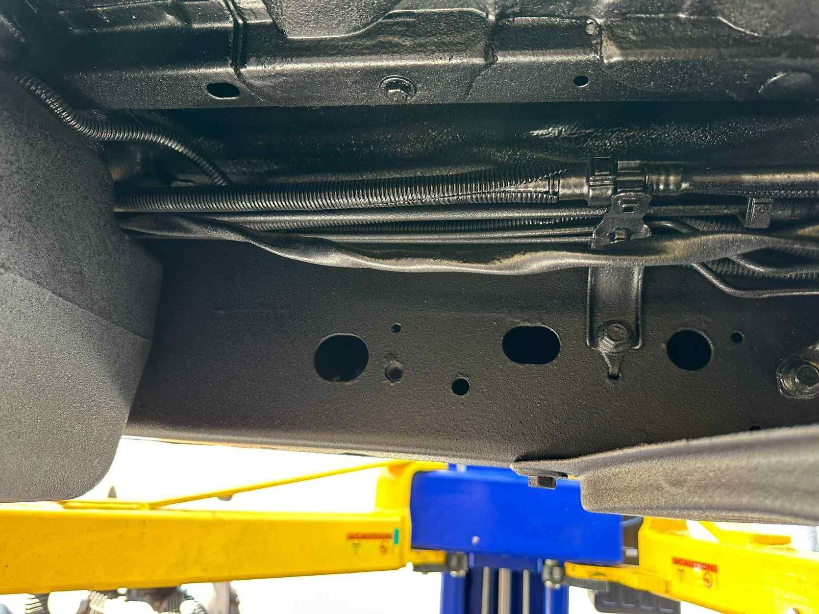 The Underside Of A Car Is Shown On A Lift — Car Detailer in Port Macquarie, NSW
