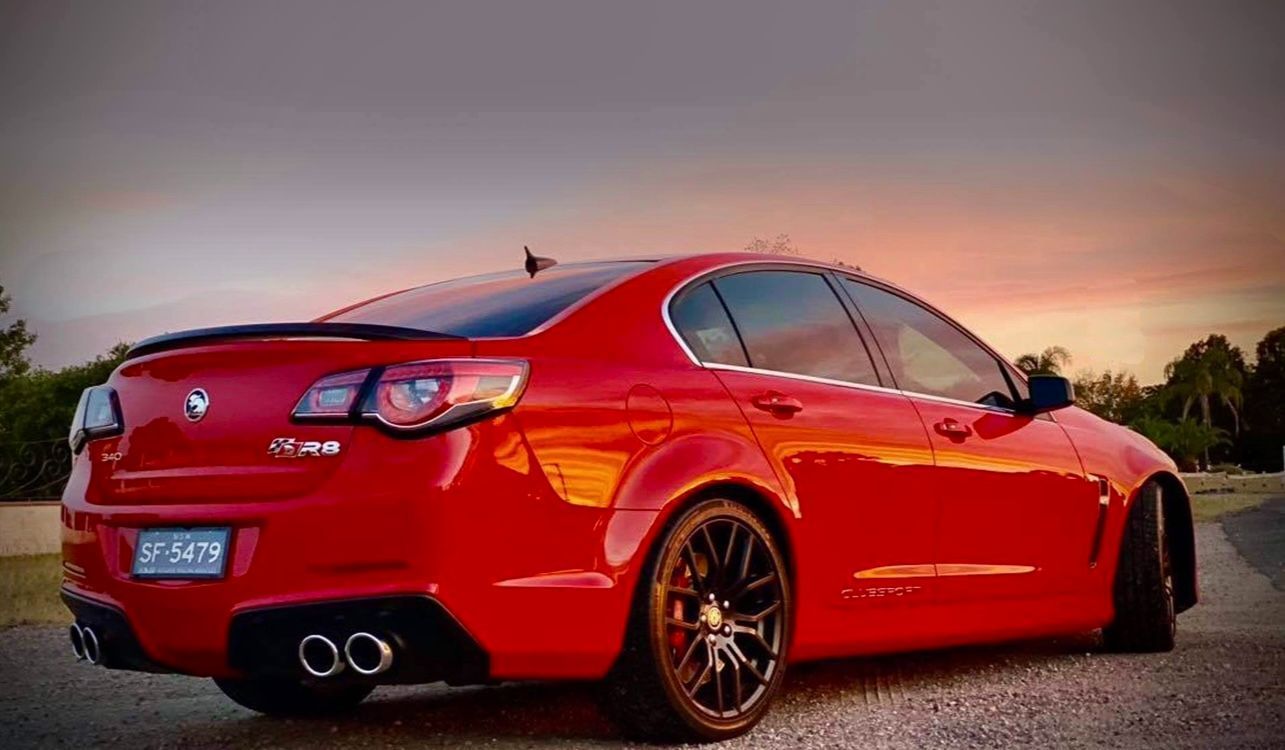 Man In A Protective Suit Is Spray Painting A White Car — Car Detailer in Port Macquarie, NSW