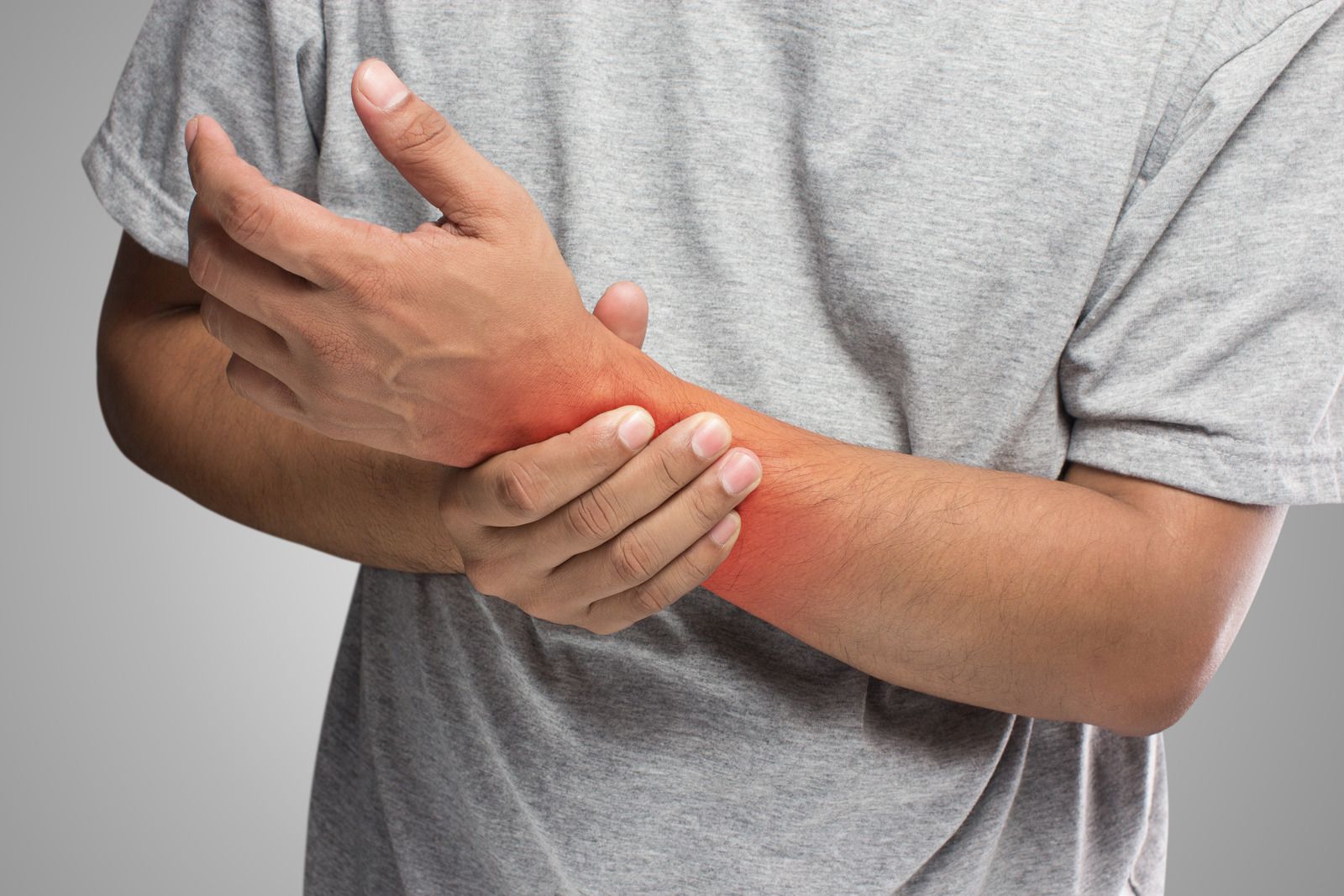 A man is holding his wrist in pain.