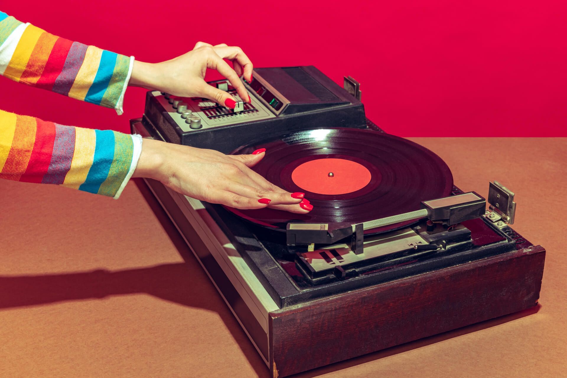 A woman is playing a record on a record player.