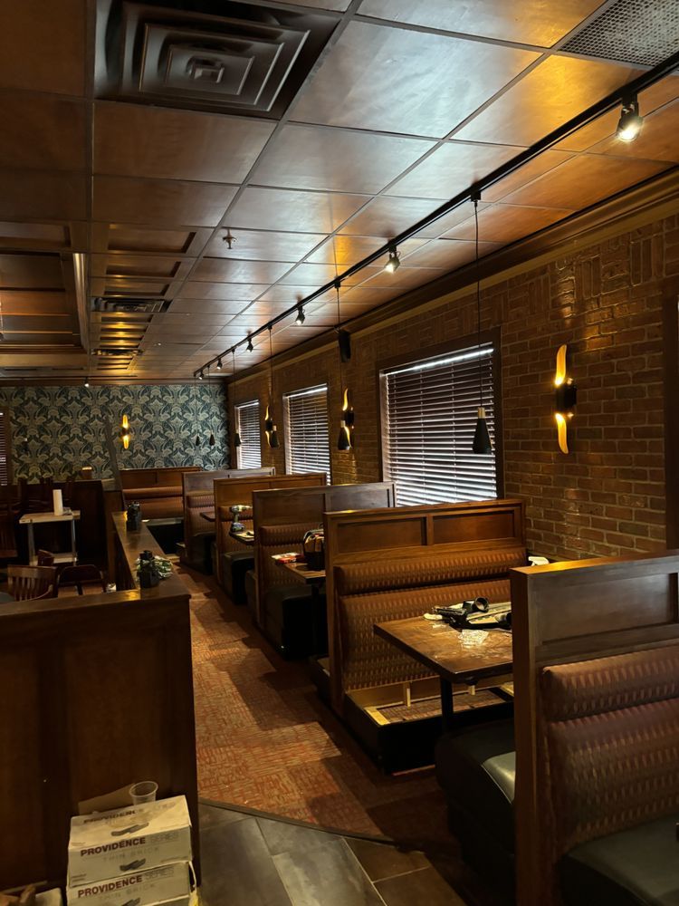 A row of booths in a restaurant with tables and chairs.