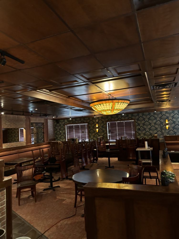 A restaurant with tables and chairs and a chandelier hanging from the ceiling