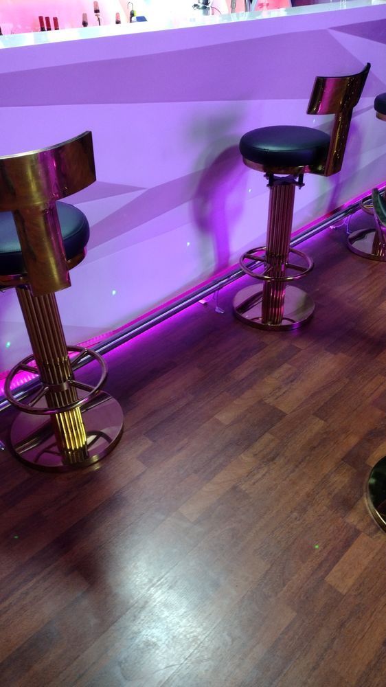 Two bar stools are sitting on a wooden floor next to a bar.