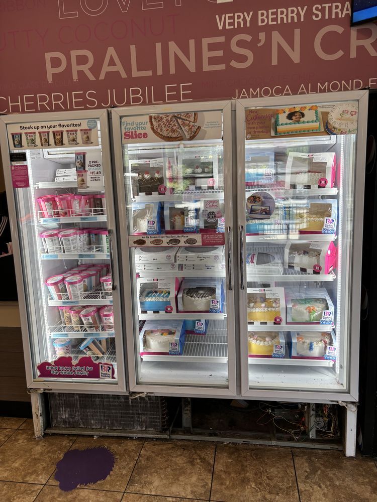 A refrigerator filled with ice cream and a sign that says pralines ' n cr