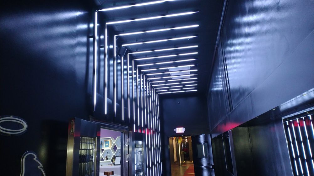 A long hallway with a lot of lights on the walls and ceiling.