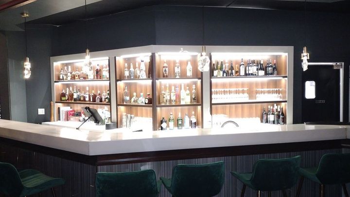 A bar with a lot of bottles on the shelves