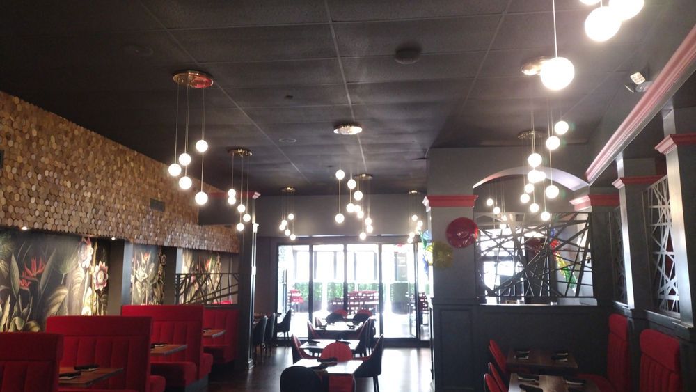 A restaurant with a black ceiling and red booths