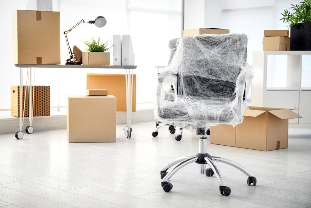 An Office Chair is Wrapped in Plastic in a Moving Office — Davis Removals & Storage in Dundowran, QLD